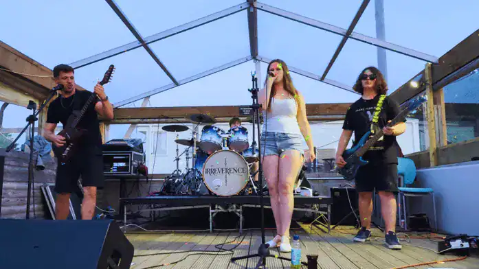 pexels-aibek-skakov-418917601-16458219 Band performing live music at Rose & Crown pub outdoor stage.